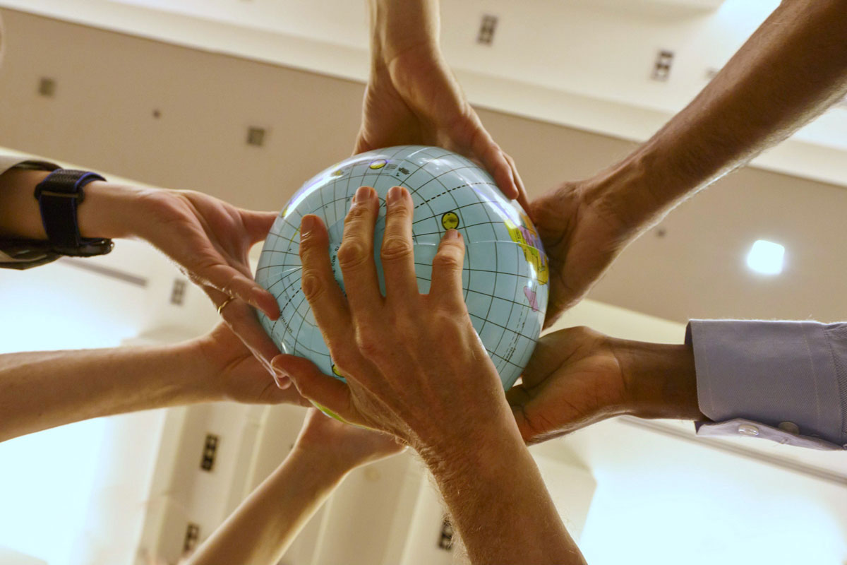 Hands holding an inflatable globe of the world